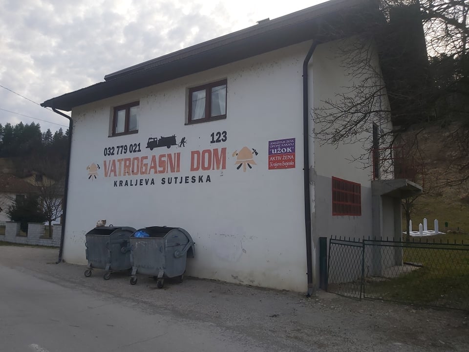 Pročelje Vatrogasnog doma u Kraljevoj Sutjesci s natpisom i kontejnerima ispred zgrade